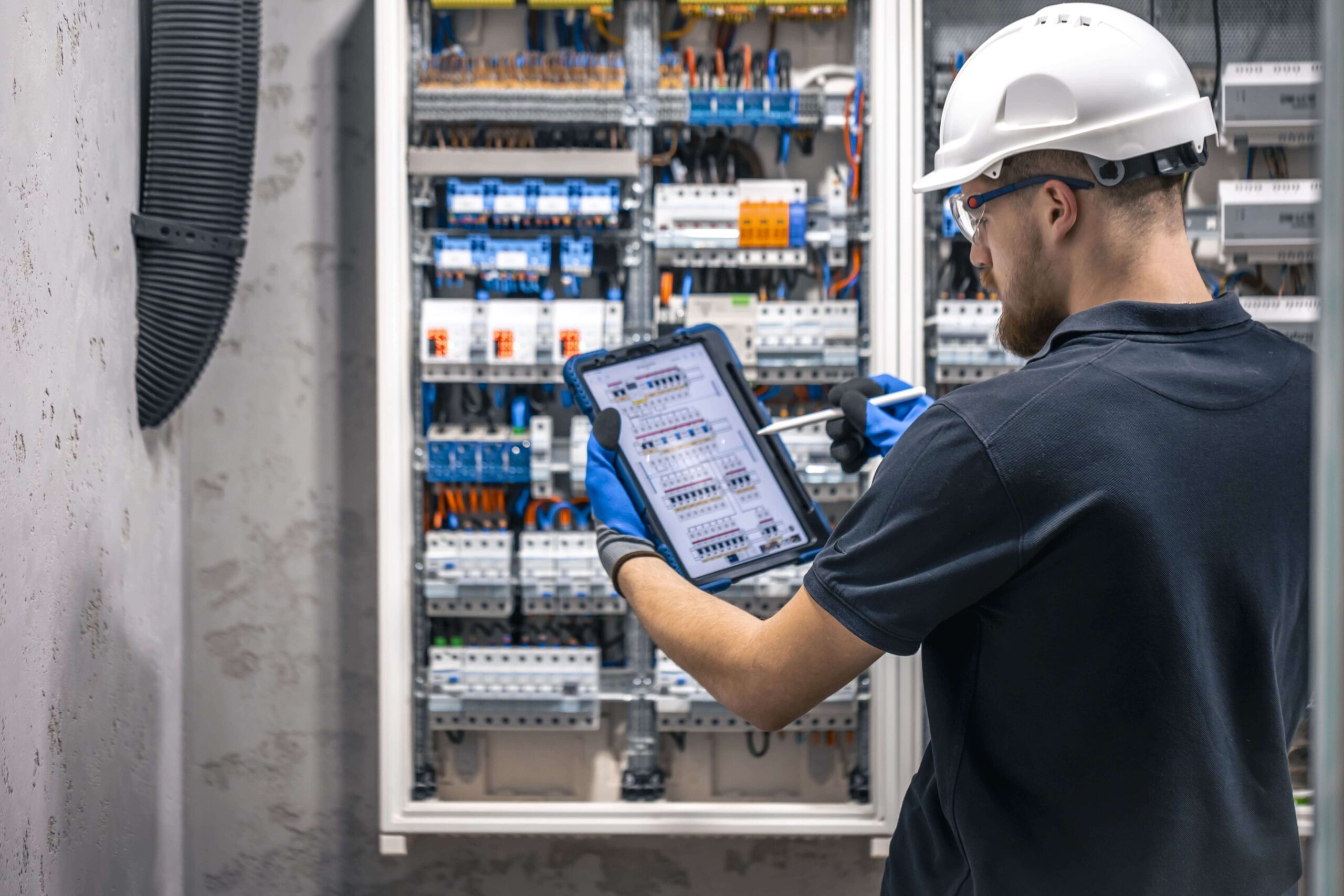 electrician-with-tablet-adjusting-circuitry-at-jun-2024-04-04-02-15-00-utc